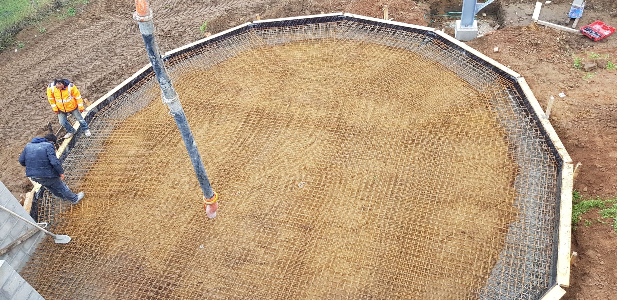 Radier de fondation en béton armé avec ferraillage et pompe à béton sur un chantier